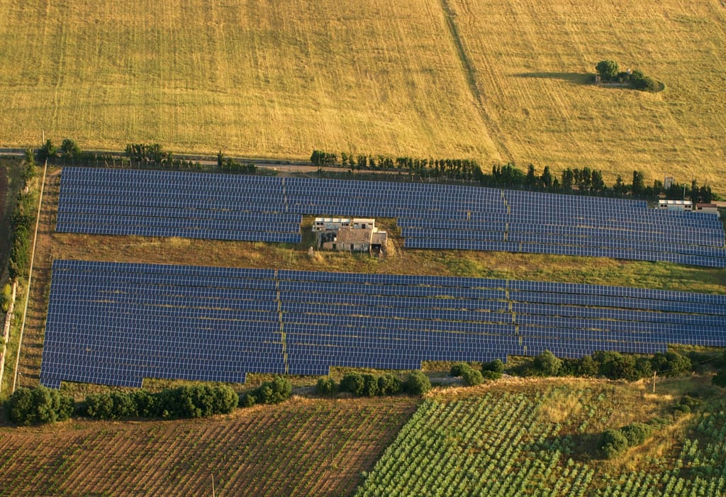 Planta fotovoltaica sobre suelo agrícola vista desde el aire, con campos de cereal y cultivos alrededor