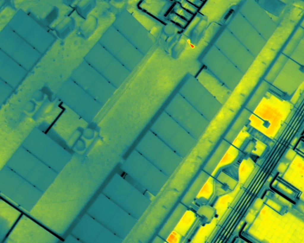 Vista cenital termografica mostrando placas solares y equipos HVAC sobre cubierta industrial