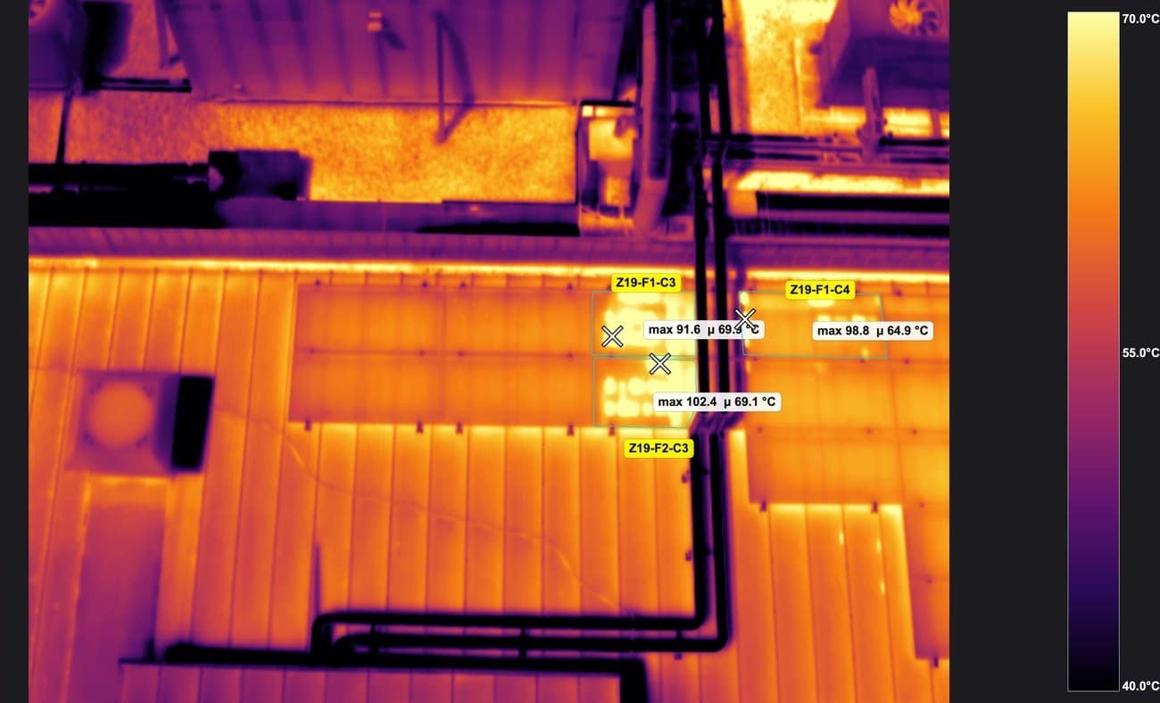 Termografía aérea de cubierta industrial con zonas de análisis y máximos de 102 °C medidos sobre conductos y tuberías