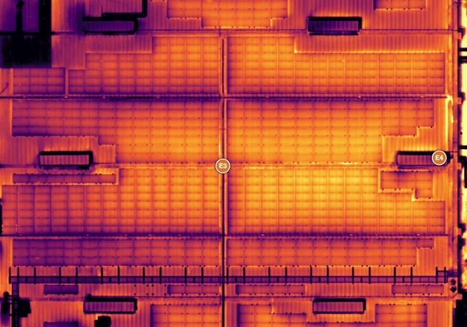 Ortofoto térmica aérea de una planta fotovoltaica industrial de 320 kWp captada con dron, con anomalías de temperatura visibles en los módulos
