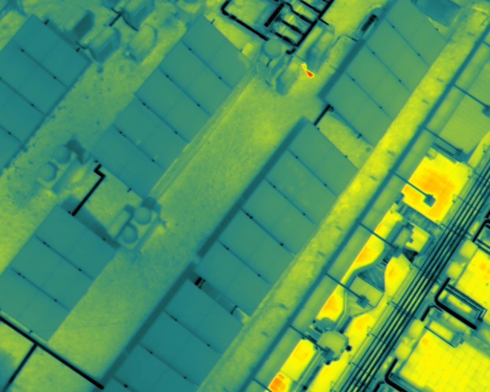 Termografía aérea de cubierta industrial mostrando placas solares y equipos HVAC con sus firmas térmicas